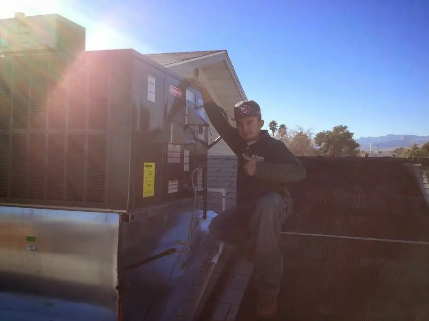 HVAC technician performing Air Duct Cleaning on a rooftop unit in Kettering